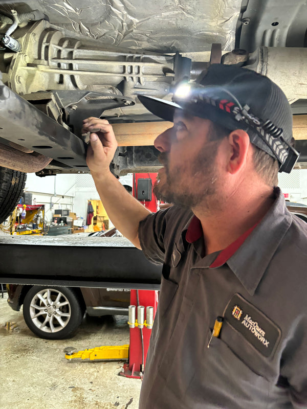 User Generated Content of the FLEXIT Headlamp 3.0 - Male under a car that up on a lift. He is inspecting it with the headlamp lighting the vehicle.